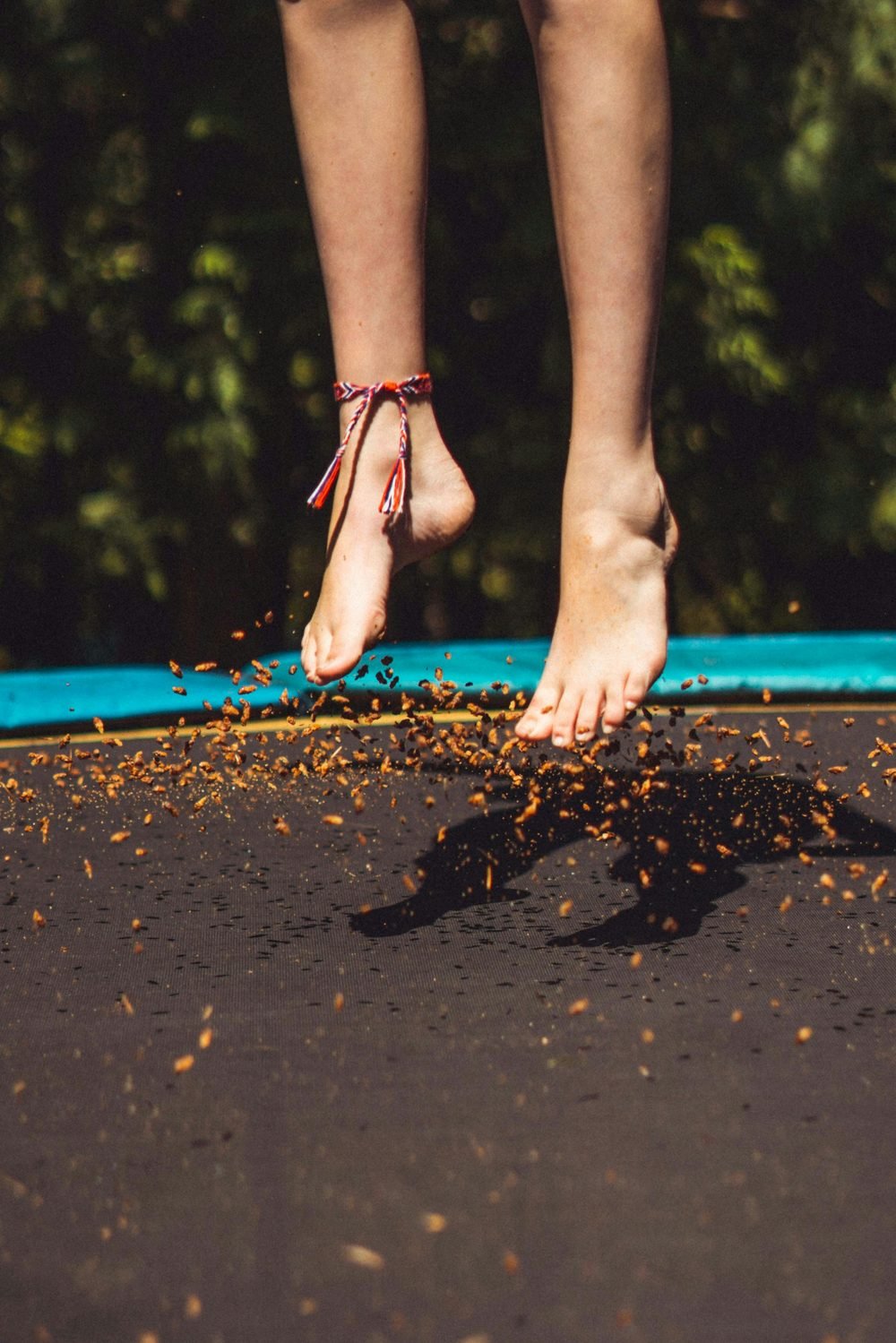 Bare feet mid-jump on a trampoline — a childlike attitude to life