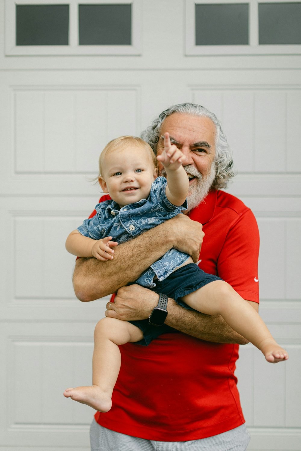 Grandfather and grandchild watering plants together