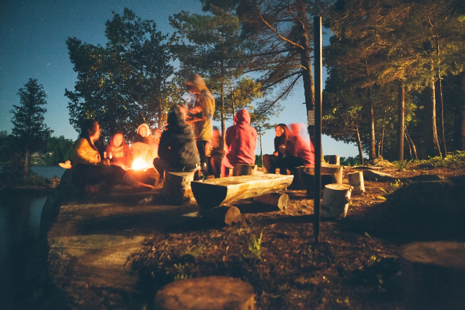 Tribe gathered around a fire at night, lakeside