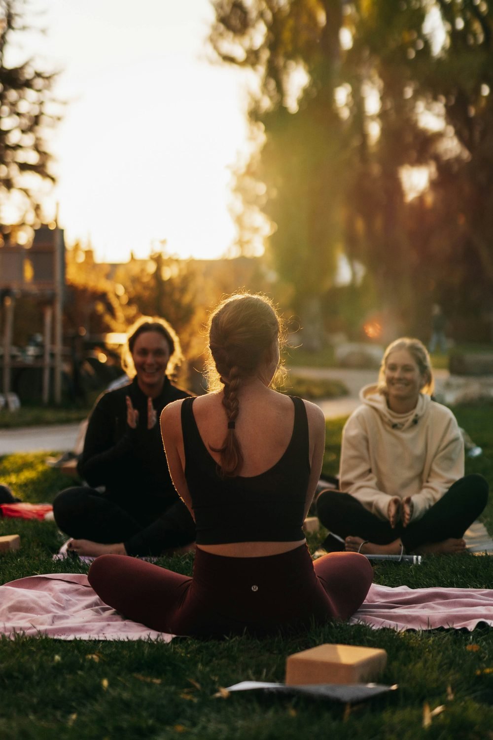 Woman meditating with others in golden hour light — a moment of turning